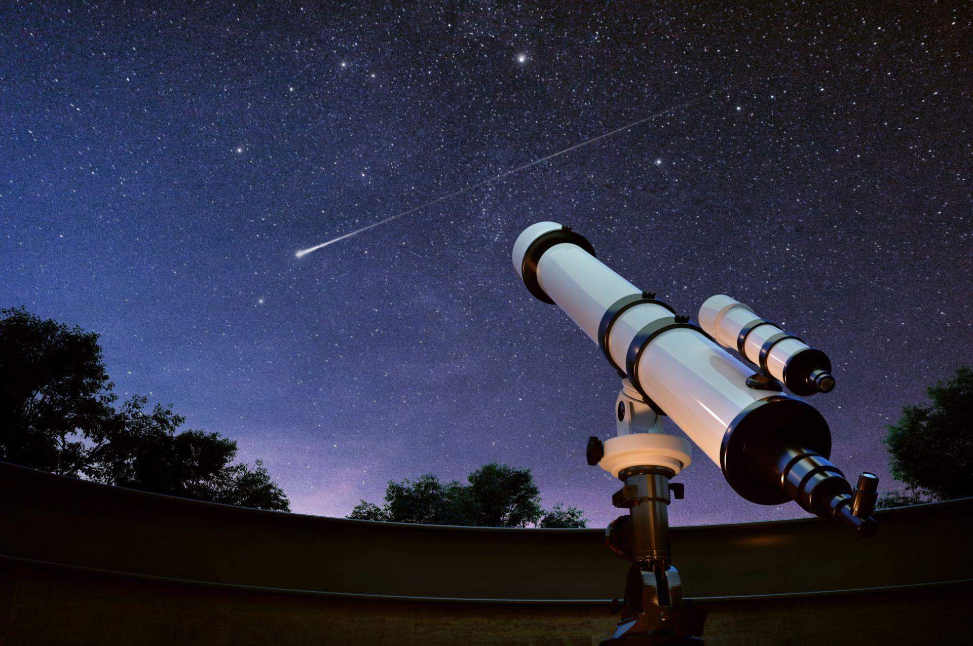 A stargazing activity at Ramsukh Resort, with a telescope pointed at the night sky filled with stars, and a shooting star visible.